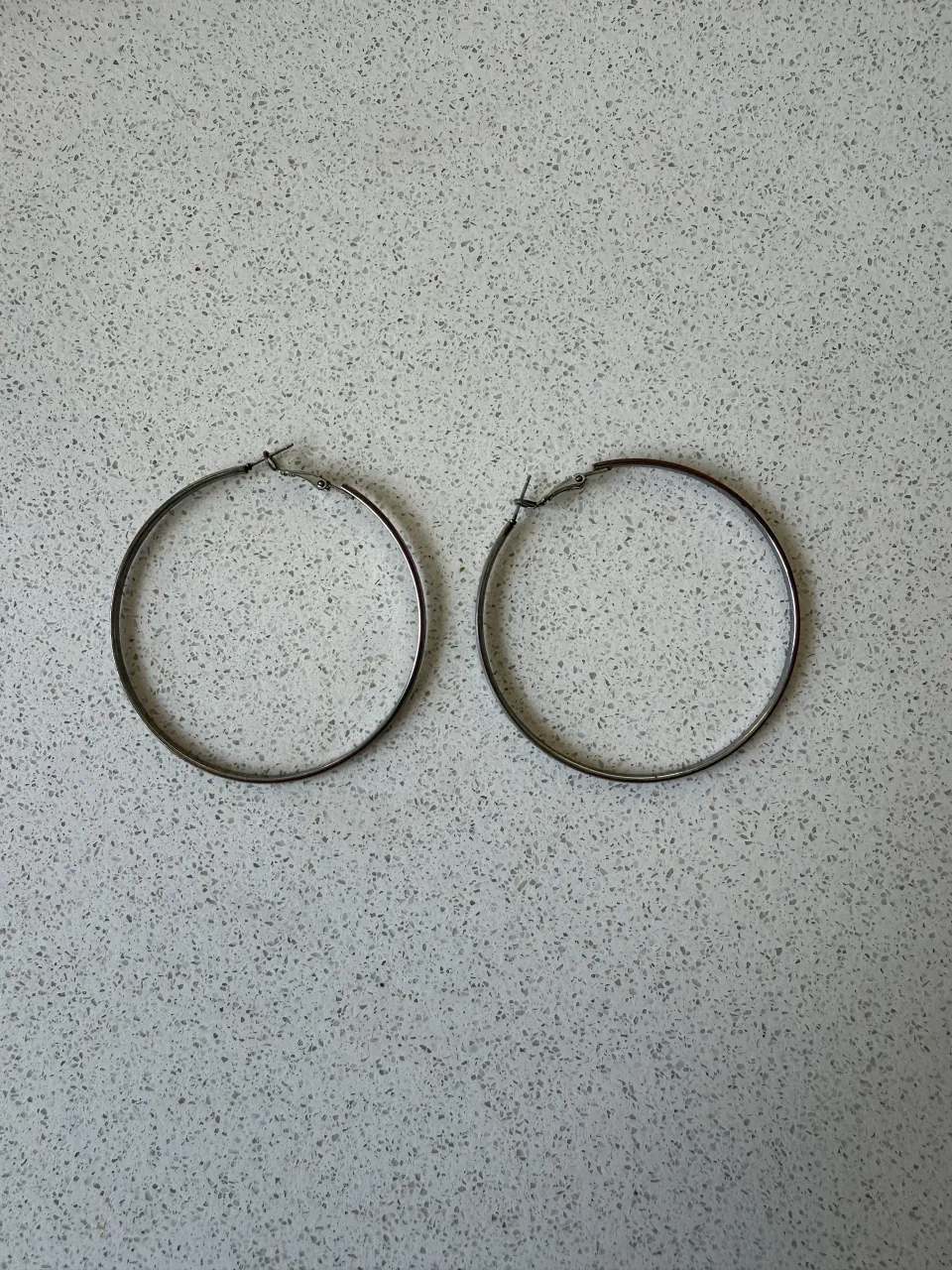 Aros argolla grandes, plateados y súper modernos. Ideales para darle un toque chic a cualquier look.