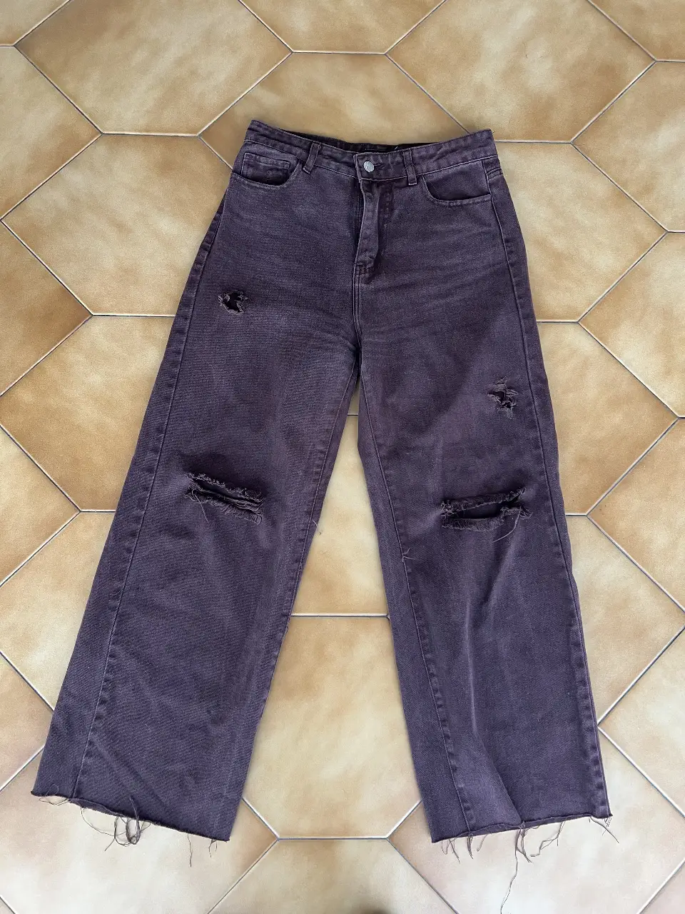 Jeans de mujer color marrón con roturas en las rodillas. Corte recto y tiro alto. Ideal para un look casual y moderno.