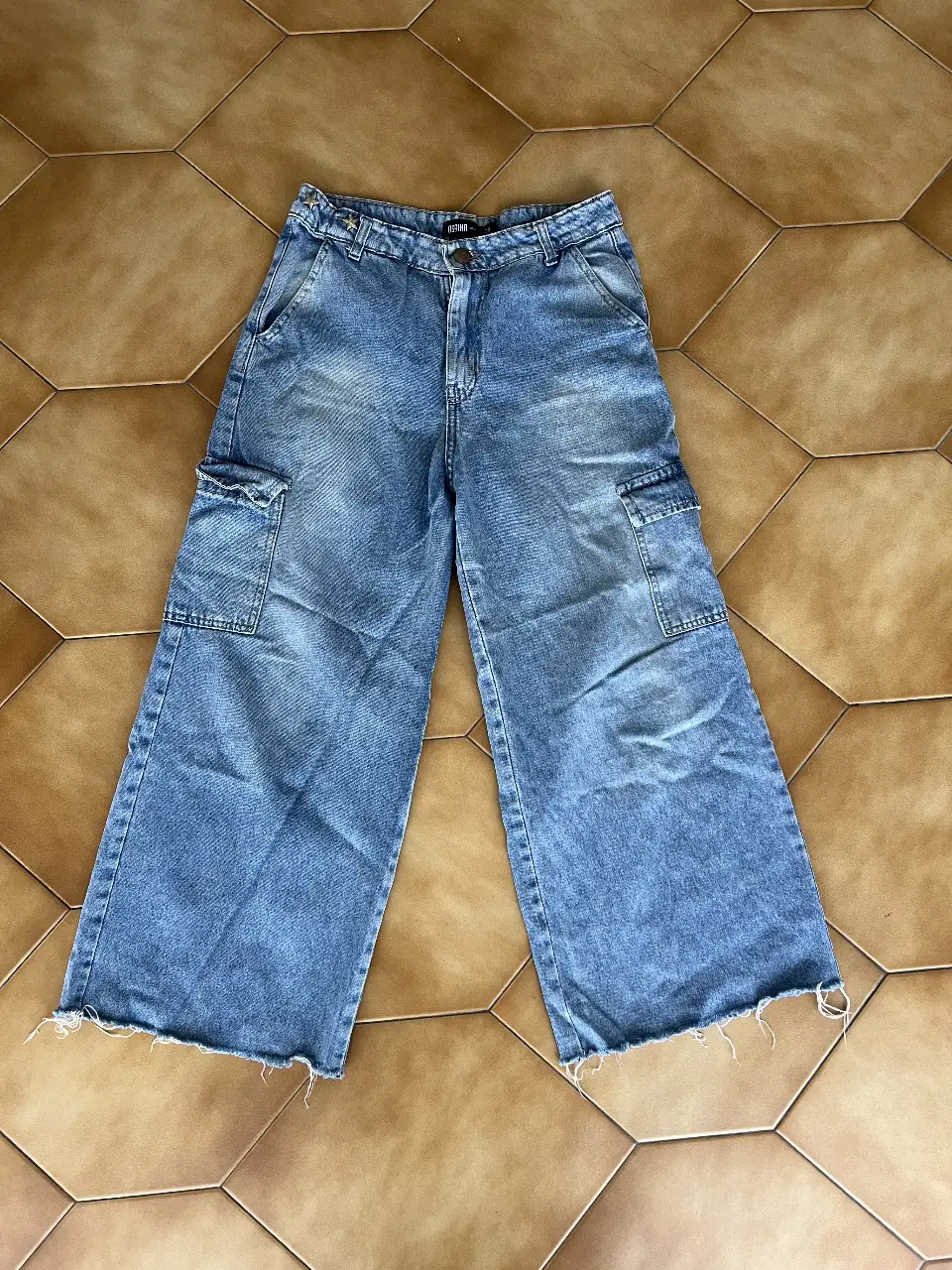 Pantalón cargo de jean azul claro, con bolsillos amplios y corte wide leg. Ideal para un look urbano y cómodo.