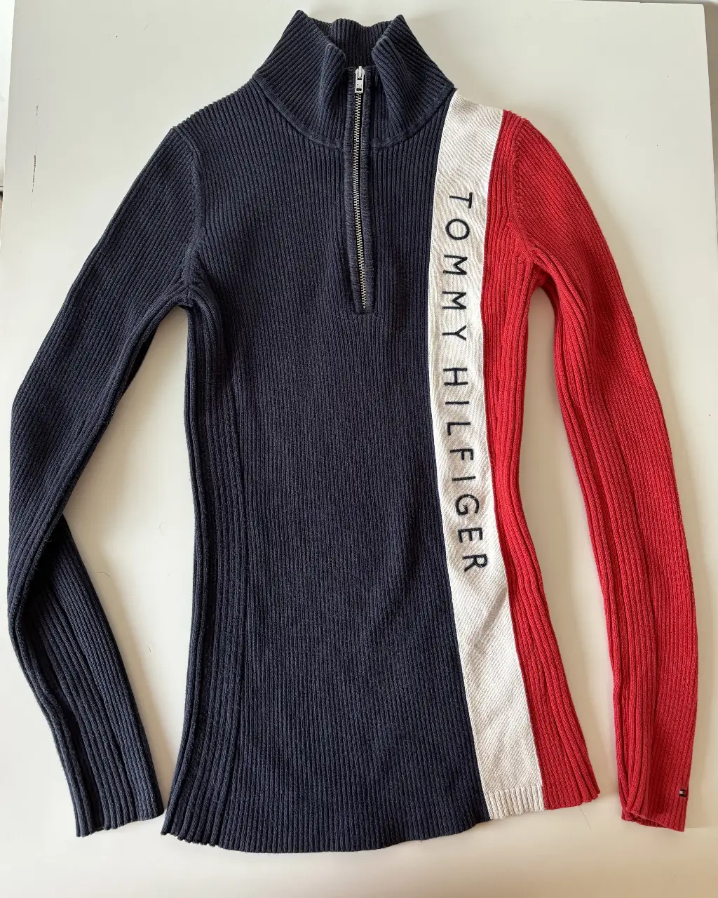 Sweater polera Tommy Hilfiger de mujer, con cierre. Diseño a bloques en azul, blanco y rojo. Cuello alto. Ideal para un look casual y abrigado.