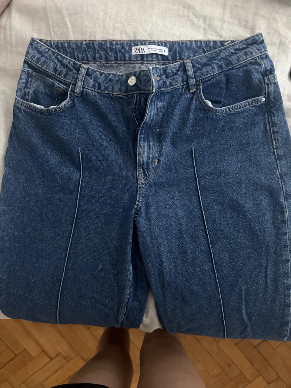 Jean zara, color azul, con bolsillos delanteros y traseros. Presenta costuras marcadas en el frente de cada pierna y en los bajos.