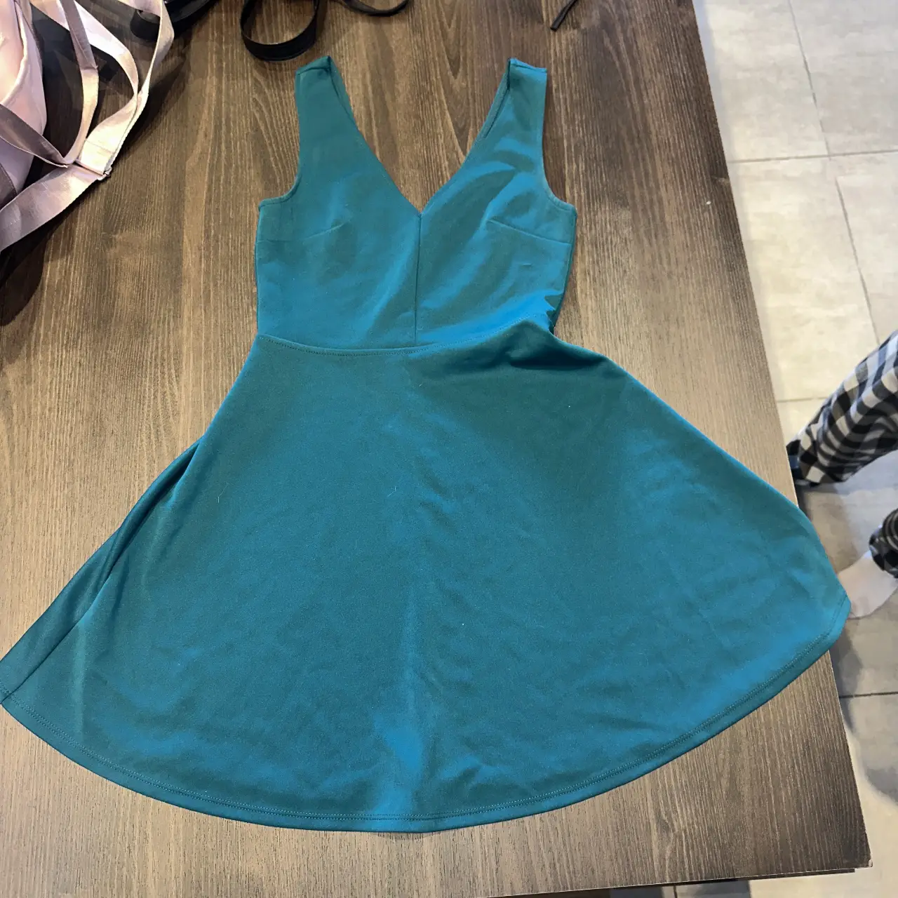 Vestido mini de color verde, con escote en V y corte en la cintura. Ideal para una salida casual o una fiesta.