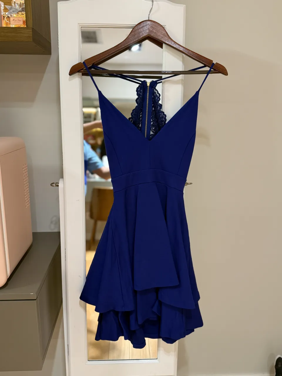 Vestido azul con tiras finas, escote en V y detalle de encaje en la espalda con cierre.