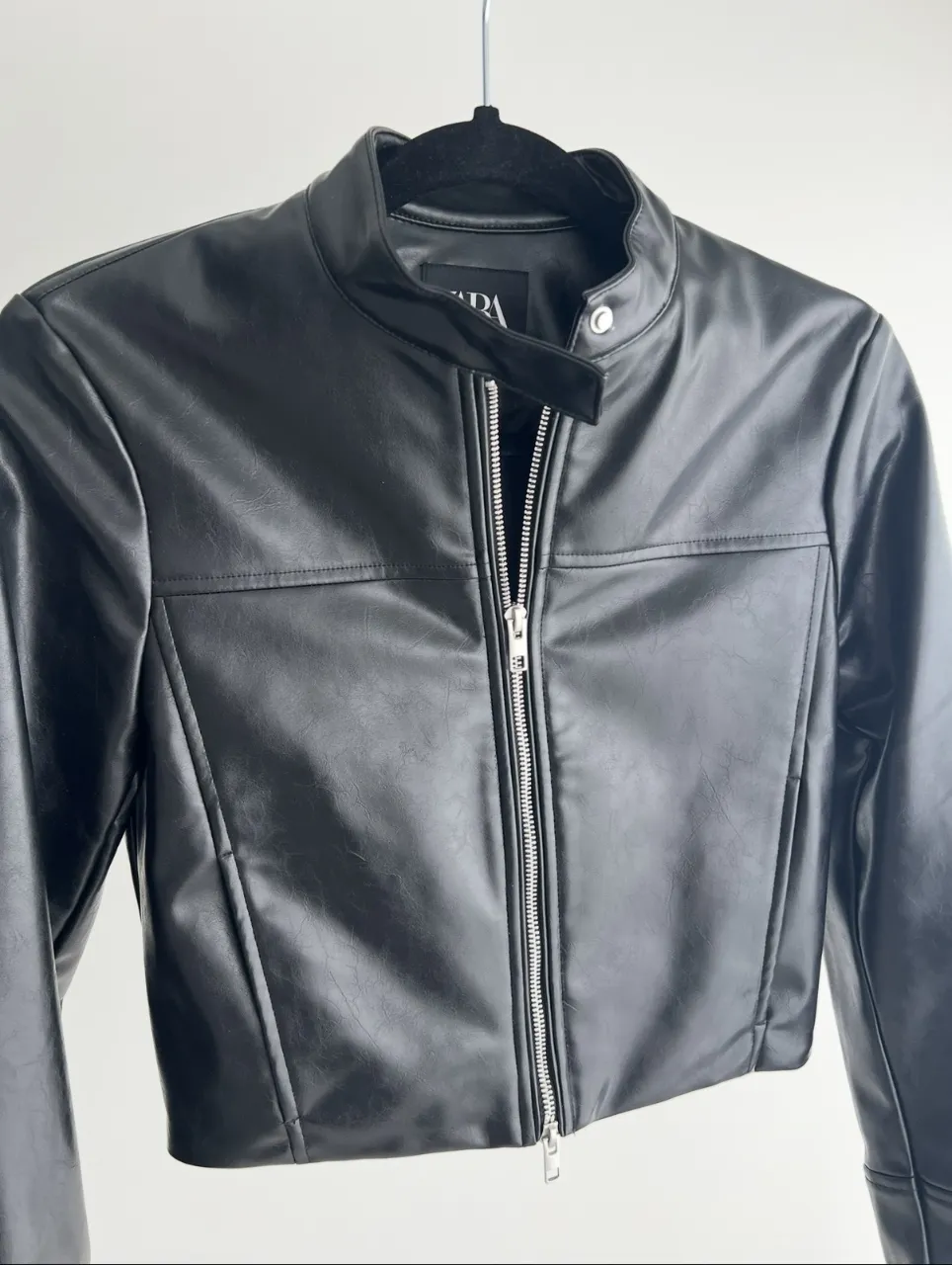 Campera negra de cuero sintético con cuello mao y cierre metálico central. Posee bolsillos frontales con cierre y detalles de costuras.