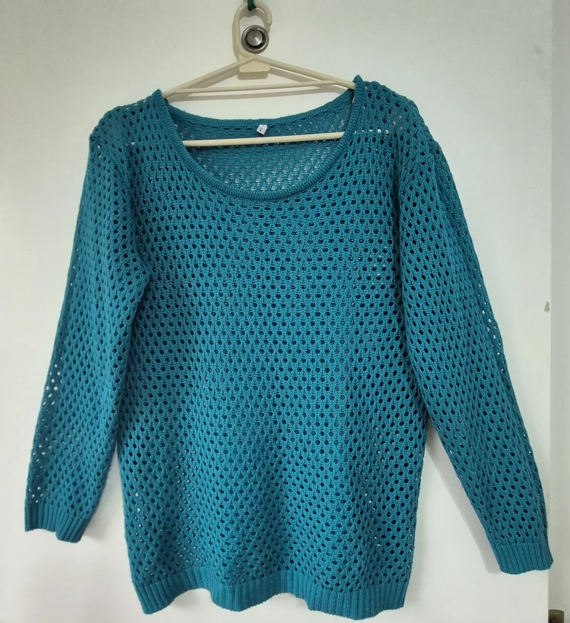 Sweater tejido calado en color turquesa. Posee mangas largas y cuello redondo. Ideal para un look casual y canchero.