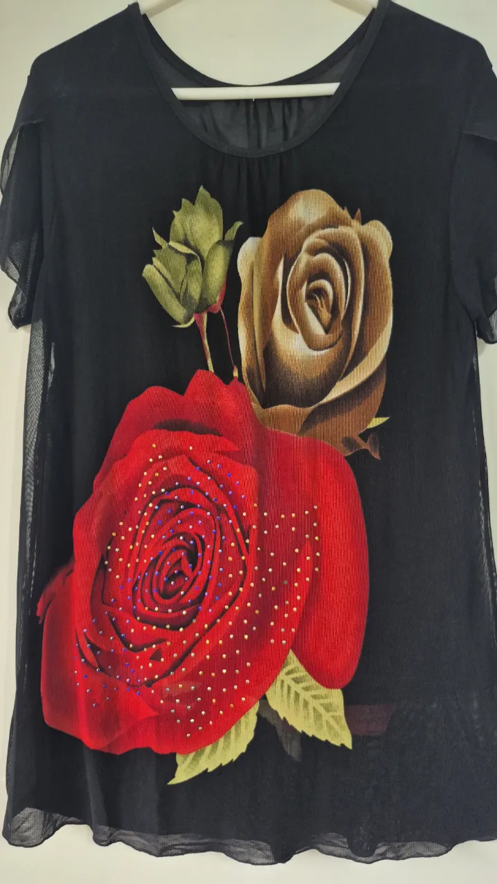 vestido negro con estampado de rosas rojas y marrones. Detalle de strass en la rosa roja. Mangas cortas con volados de tul. Ideal para un look canchero y femenino. forrado