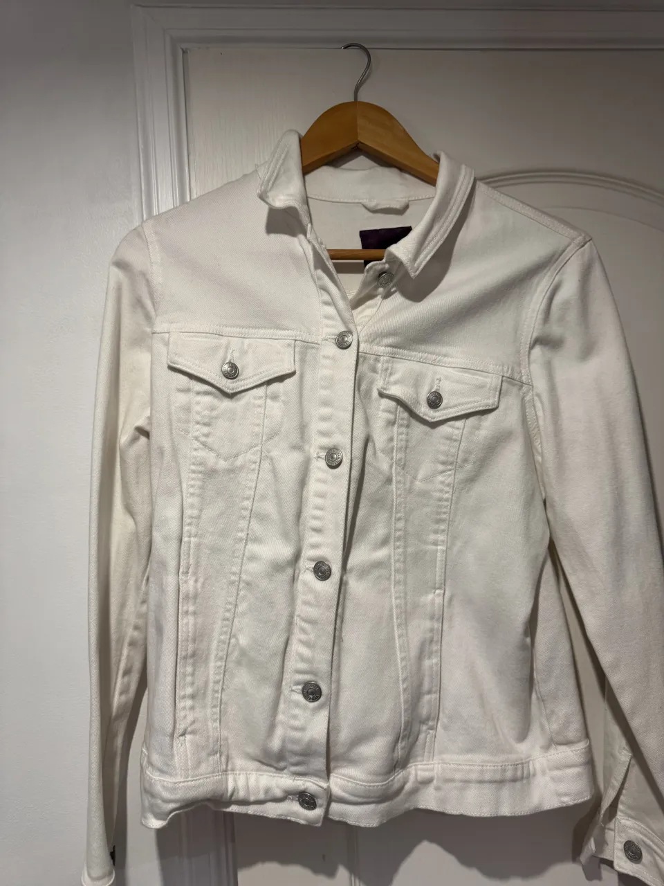 Campera de jean blanca, con botones al frente y en los bolsillos.