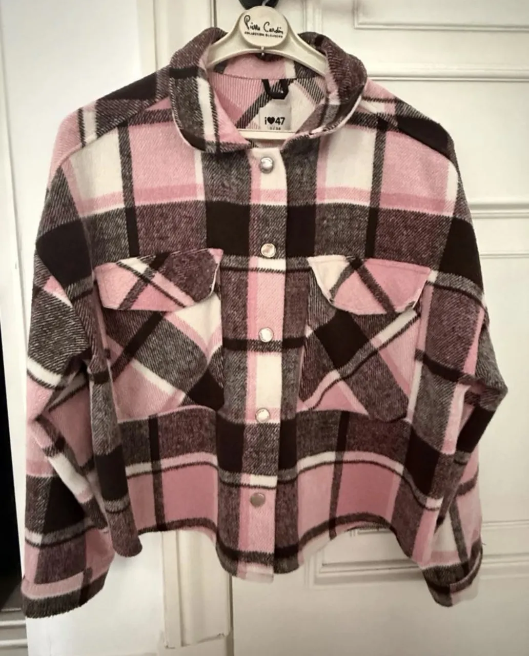 Camisa a cuadros de manga larga con botones al frente y dos bolsillos en el pecho. Puños con botón.