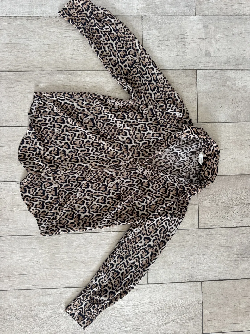 Camisa estampada con motivo de leopardo, manga larga y cuello camisero.