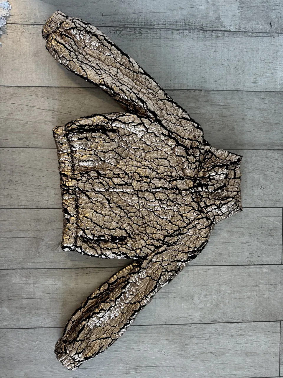 Campera dorada y negra con quebraduras, con botones.