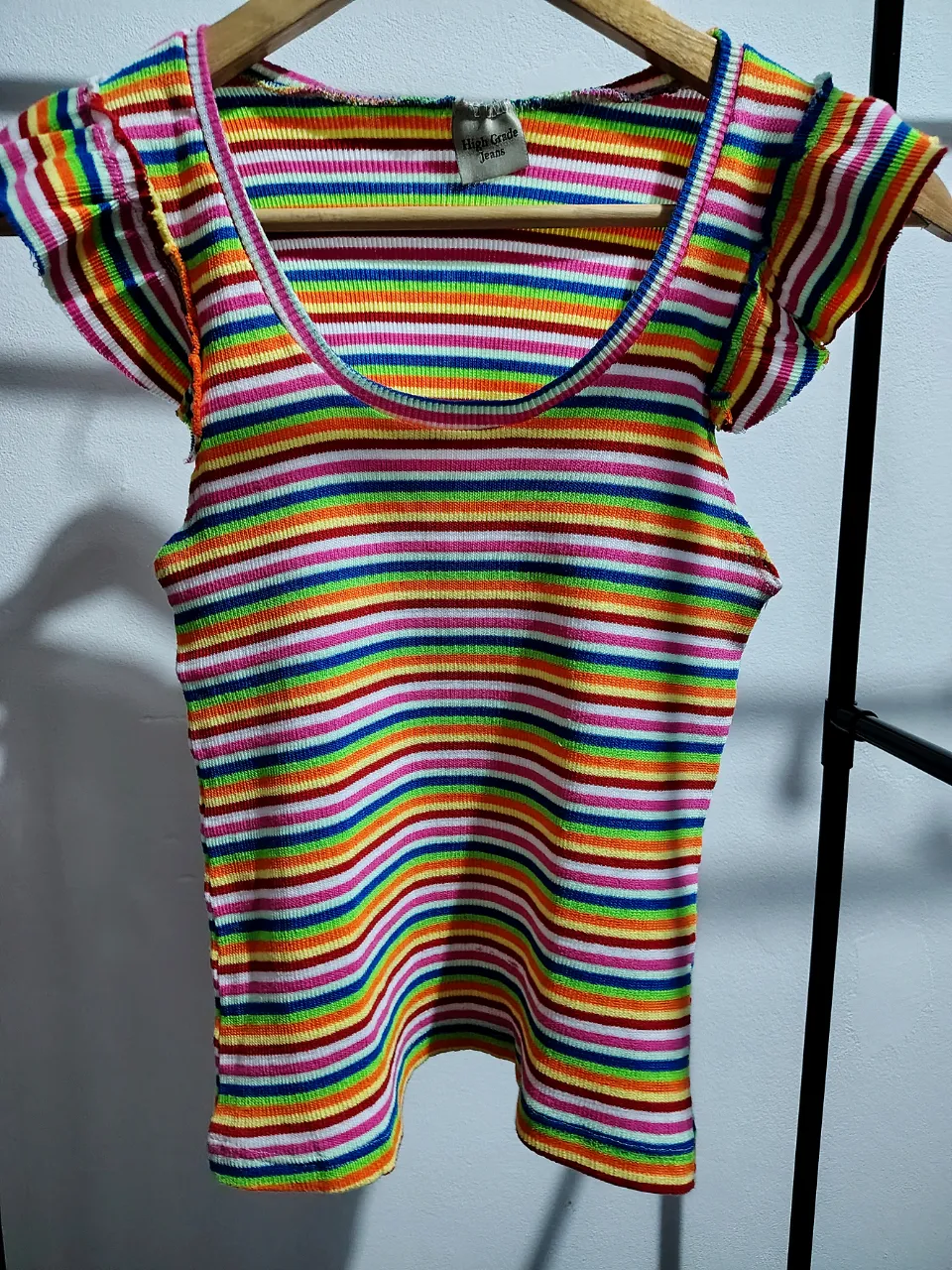 Remera de hilo bremer elastizado a rayas multicolor con mangas cortas con volados y cuello redondo. Abarca hasta un talle M inclusive.