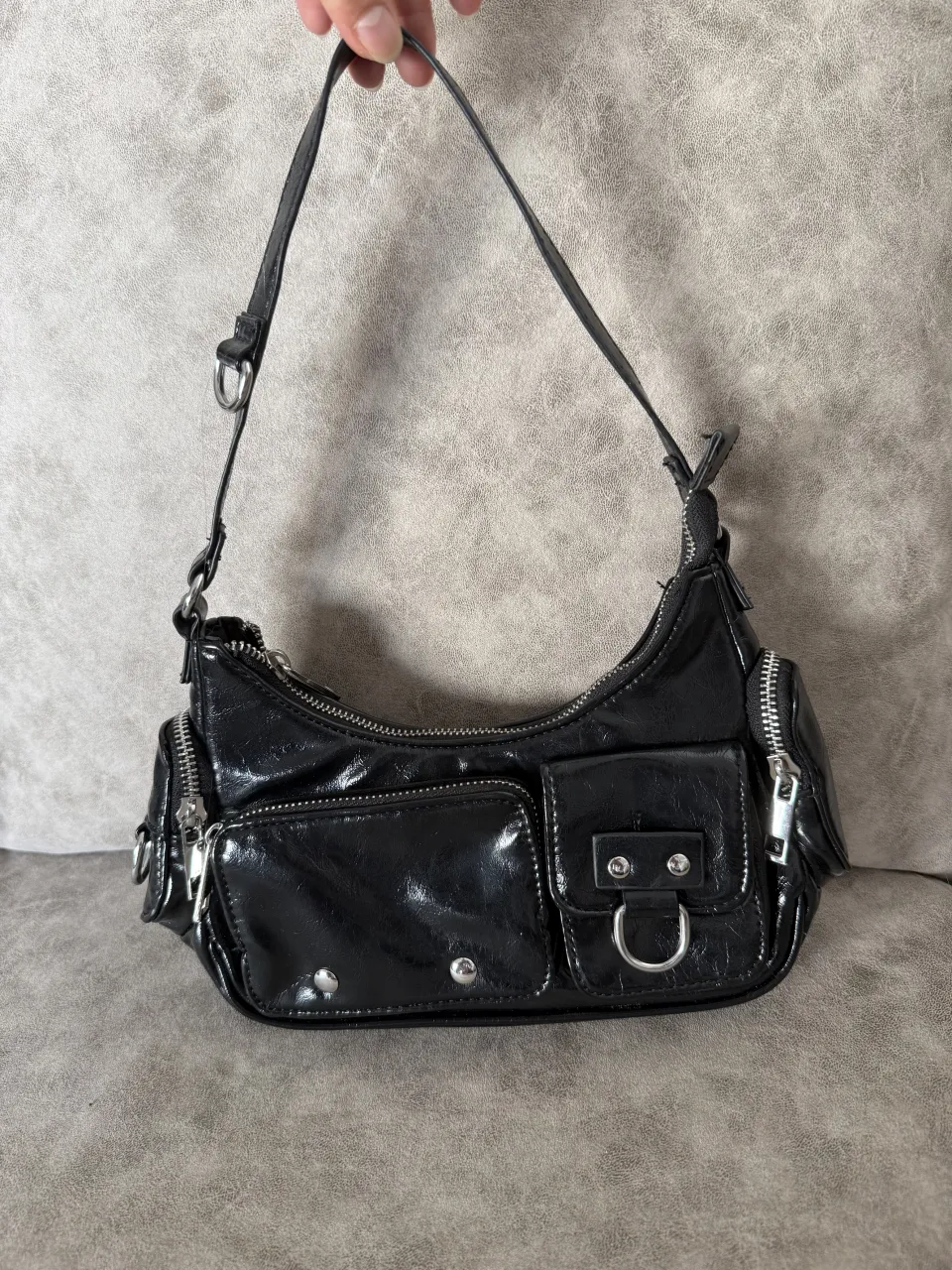 Shoulder bag, estilo Y2K, con múltiples bolsillos y detalles metálicos. 