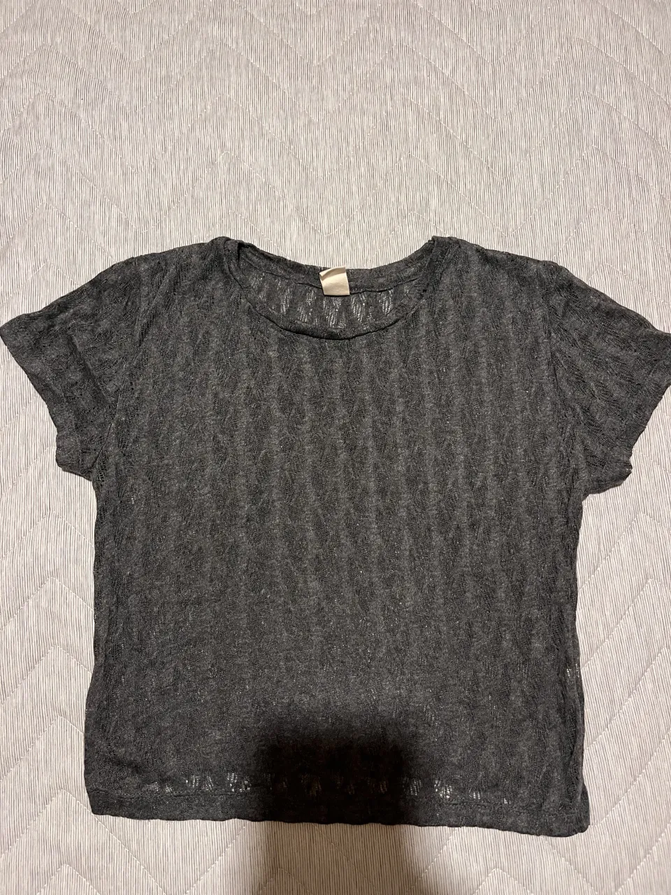 Remera gris de manga corta con textura tejida.