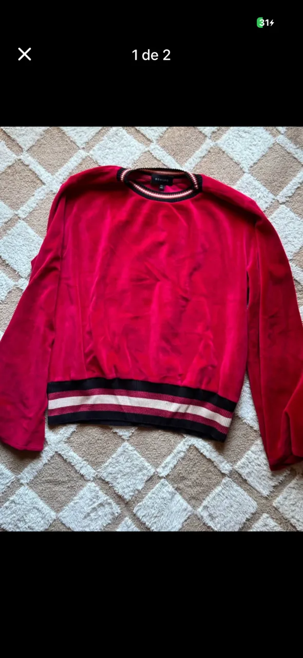 Sweater de terciopelo color fucsia con cuello redondo y puños y cintura con detalles de rayas.