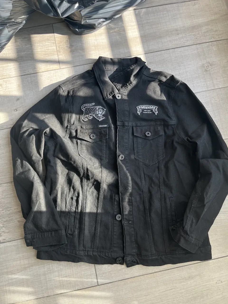 Campera de jean negra con detalles bordados de la marca Family D.R.G. en la espalda y en el frente. Talle X-Large.