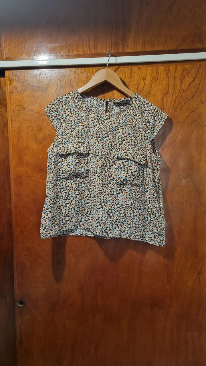 Remera estampada con cuello redondo y mangas cortas. Posee dos bolsillos falsos en la parte delantera. Ideal para un look casual y moderno.