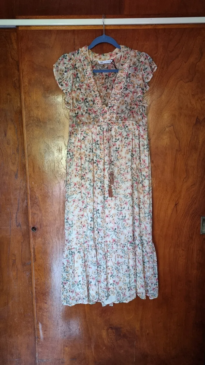 Vestido largo estampado floral, con volados en mangas y escote en V con detalle de lazo y borla. Ideal para un look romántico y fresco.