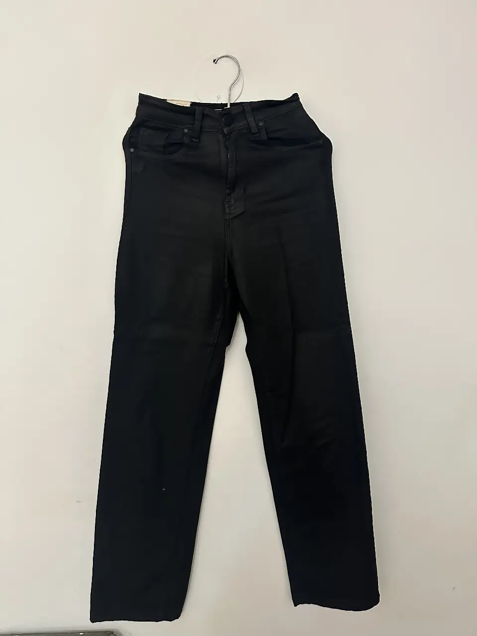 Jeans rectos negros de tiro alto tipo cuero, ideales para un look casual y versátil. Confeccionados en tela de jean resistente y cómoda, perfectos para combinar con cualquier outfit. medidas: cintura sin estirar 29 cm - cede hasta 33 cm. largo 106. Es talle 1