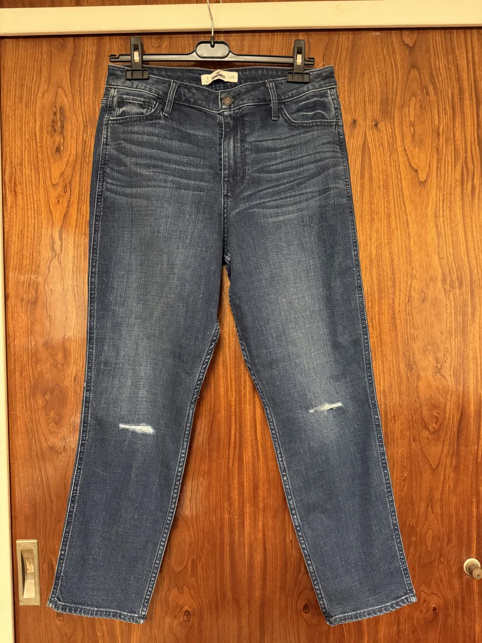 Jeans de denim azul con roturas sutiles en ambas rodillas. Cierre de botón y cierre. Es un talle 9 US. Tiene de medidas: 39cm de cintura, 45 cm de cadera y 28cm de tiro 