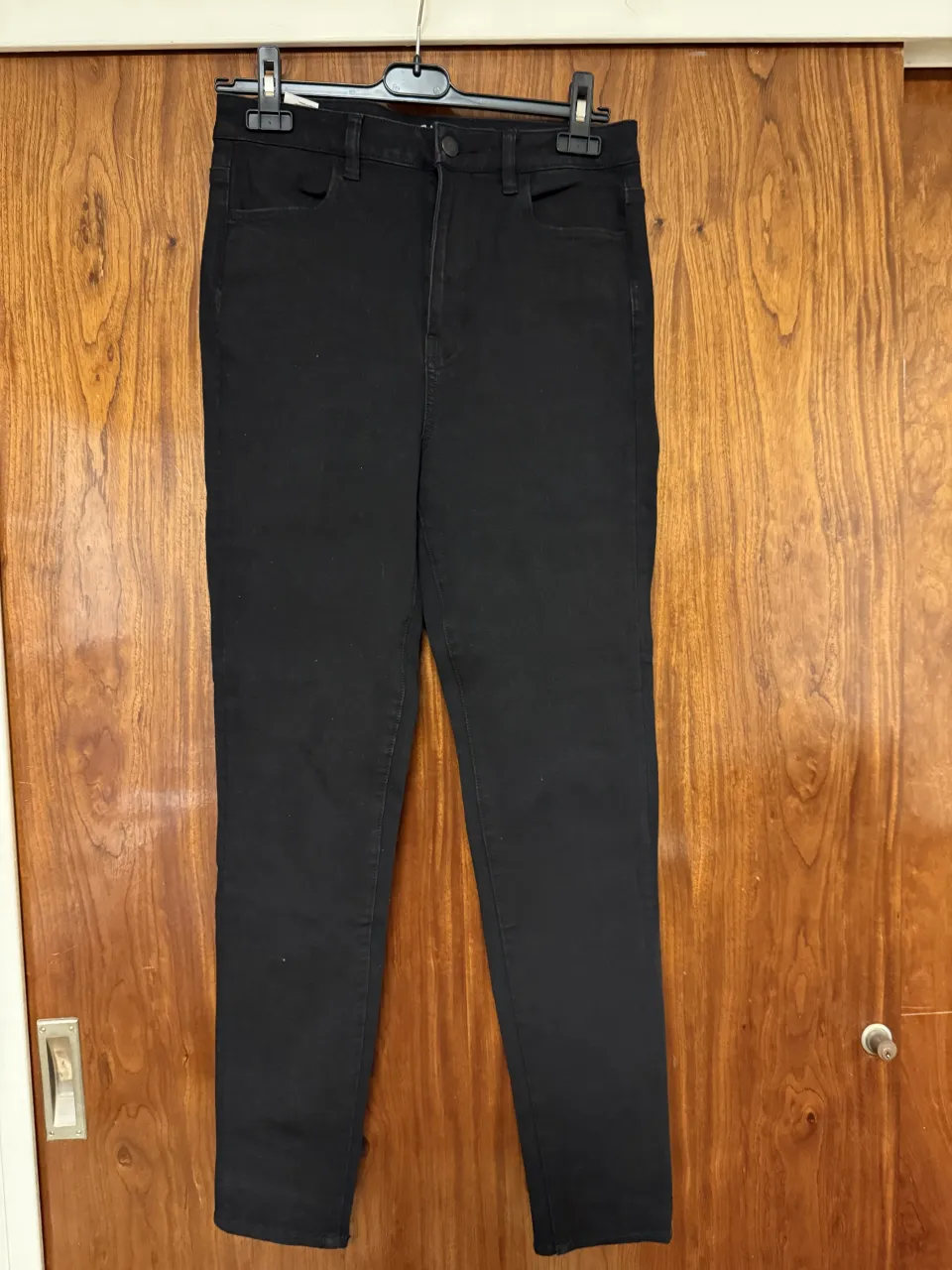 Jeans negros de tiro alto con cinco bolsillos y cierre. Es talle 10 US. Tiene de medias: 37 cm de cintura, 42cm de cadera y 32cm de tiro (es tiro alto!). Es una prenda con tela elastizada, así que cede y se ajusta. Puede servirte incluso si normalmente usás un talle un poco más grande.