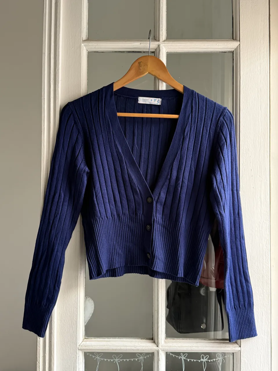 Cardigan azul marino de tejido acanalado con botones al frente y cuello en V.