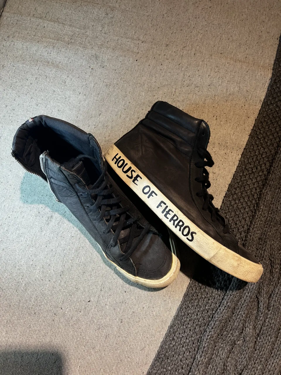 Zapatillas marca “HERENCIA” de cuero negras, estilo botita, con cierre lateral y cordones. Detalle de inscripción "HOUSE OF FIERROS" en la suela. Ideales para un look rockero!