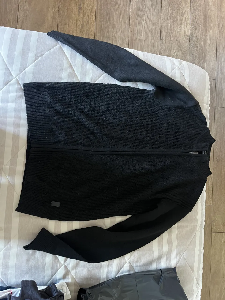 Sweater negro con cierre completo y cuello con detalles grises. Posee textura en el tejido 