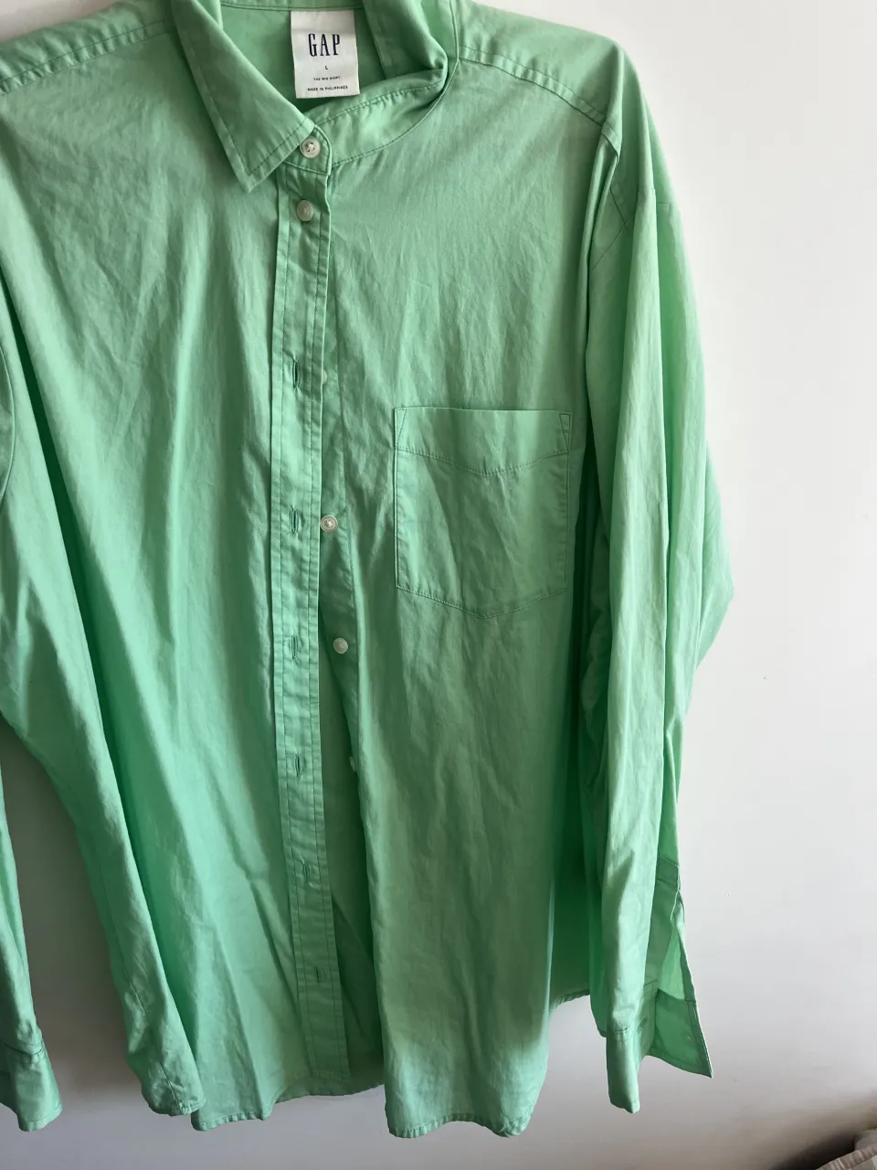Camisa manga larga color verde . Marca GAP. Posee un bolsillo en el frente izquierdo y botones blancos.