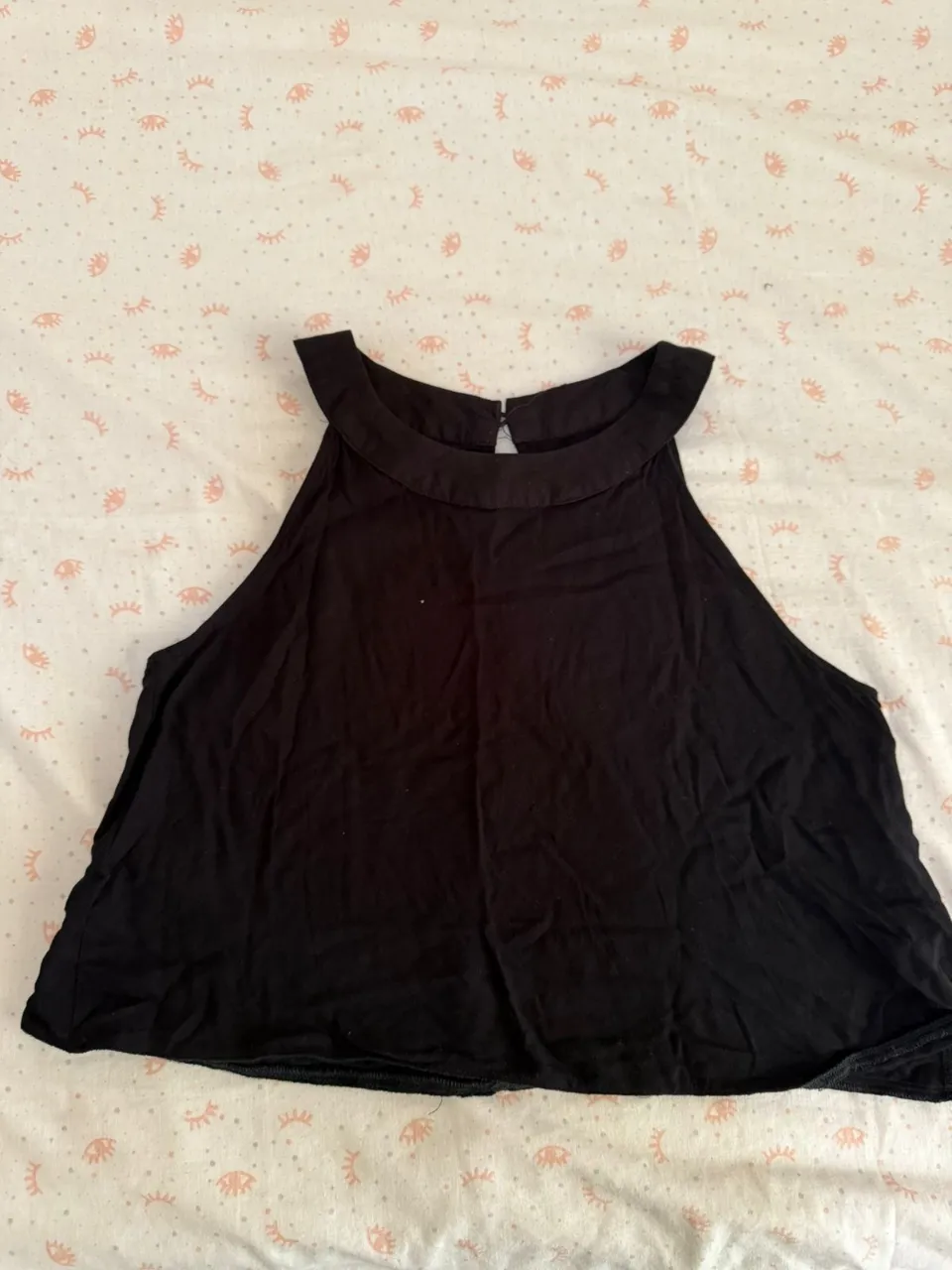 Musculosa negra con cuello redondo y detalle de corte en la nuca.