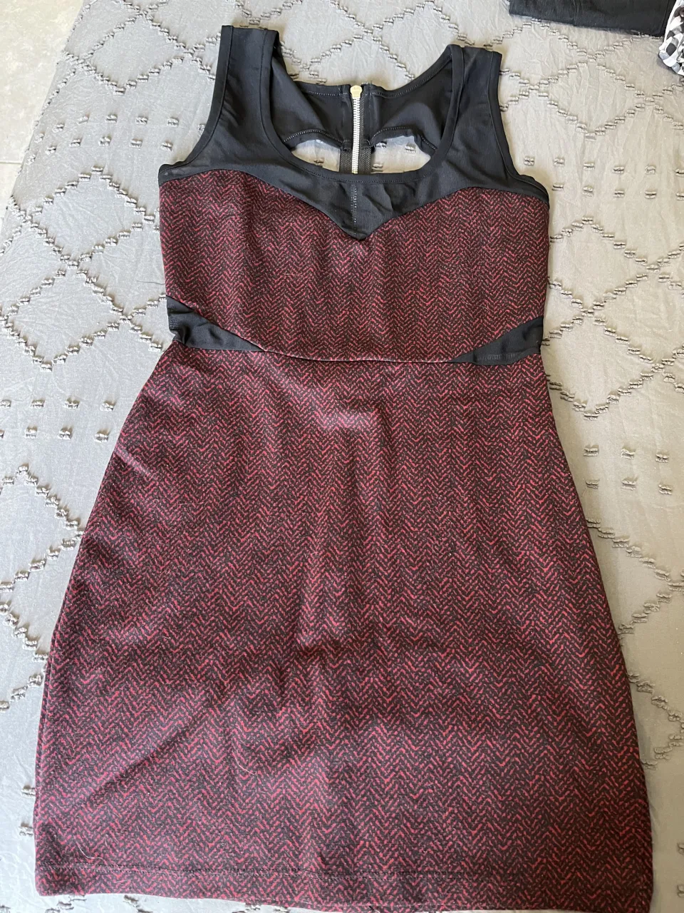 Vestido corto de fiesta, con detalles de corte en la espalda y cierre metálico. Diseño moderno y elegante, ideal para eventos especiales.