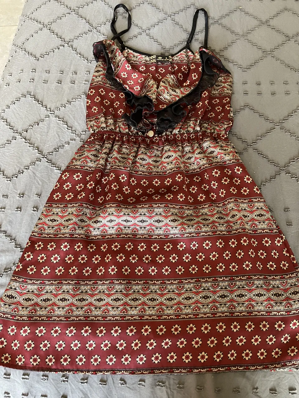 Vestido corto estampado con volados y detalles de encaje negro. Ideal para un look boho chic o casual.