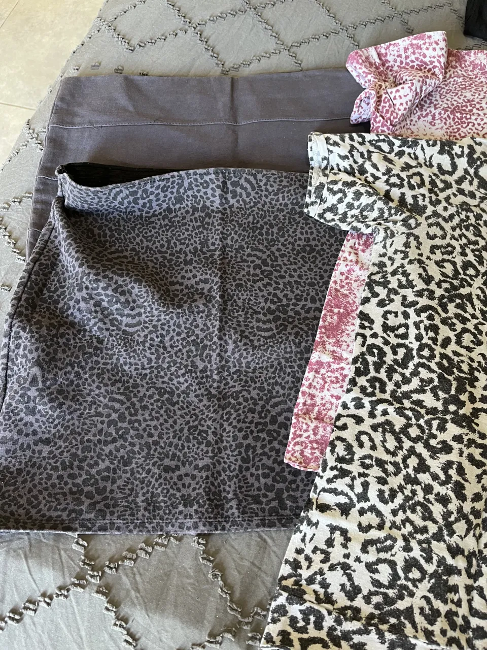 lote de 2 Remeras de manga corta con estampa animal print en gris  y negro y gris y bordo. 2 minifaldas una lisa y una animal print gris.