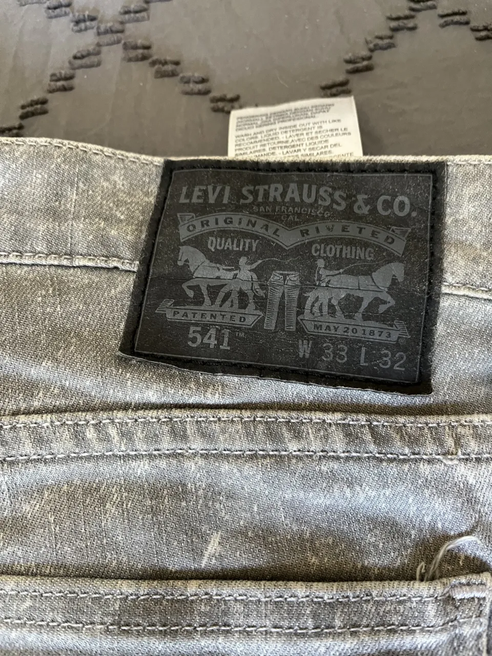 Jeans Levi's grises con efecto desgastado. Modelo clásico de 5 bolsillos, tiro medio y corte recto. Perfectos para un look casual y moderno. talle 54 argentina