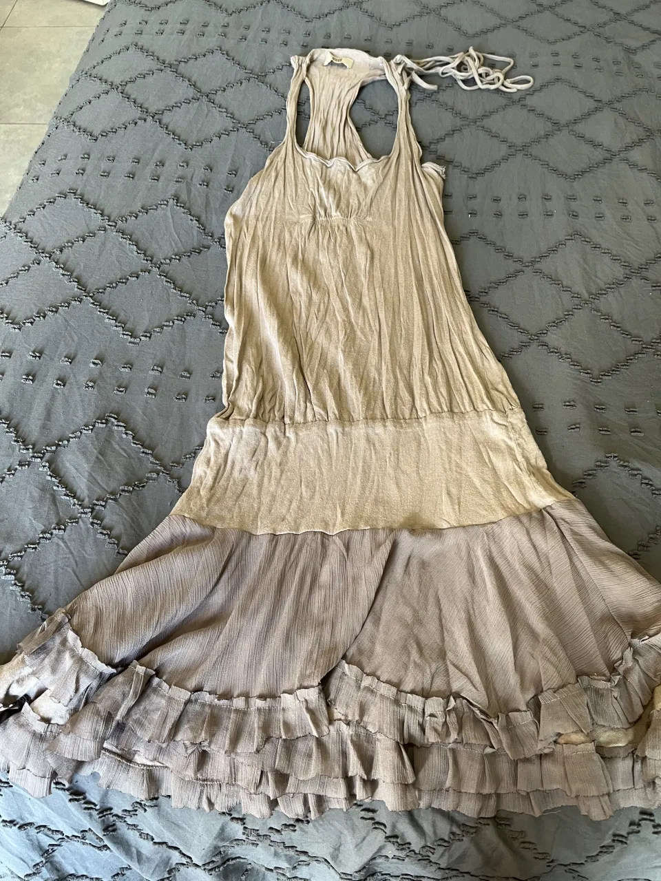 Vestido a la rodilla de tela liviana, con volados en la falda y tiras para atar en la espalda. Ideal para un look boho chic.