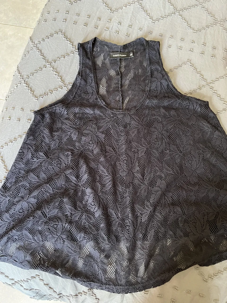 Musculosa de encaje negra, ideal para usar como salida de playa o para un look canchero y fresco. Su diseño delicado la hace perfecta para combinar con tops o corpiños. talle 42