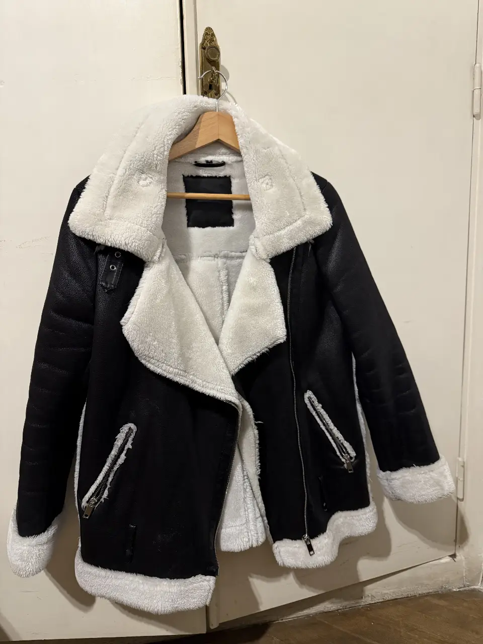Campera de cuero sintético para mujer, estilo biker, con forro de piel sintética en color blanco. Posee cierre y bolsillos con cremallera. Ideal para el invierno.
