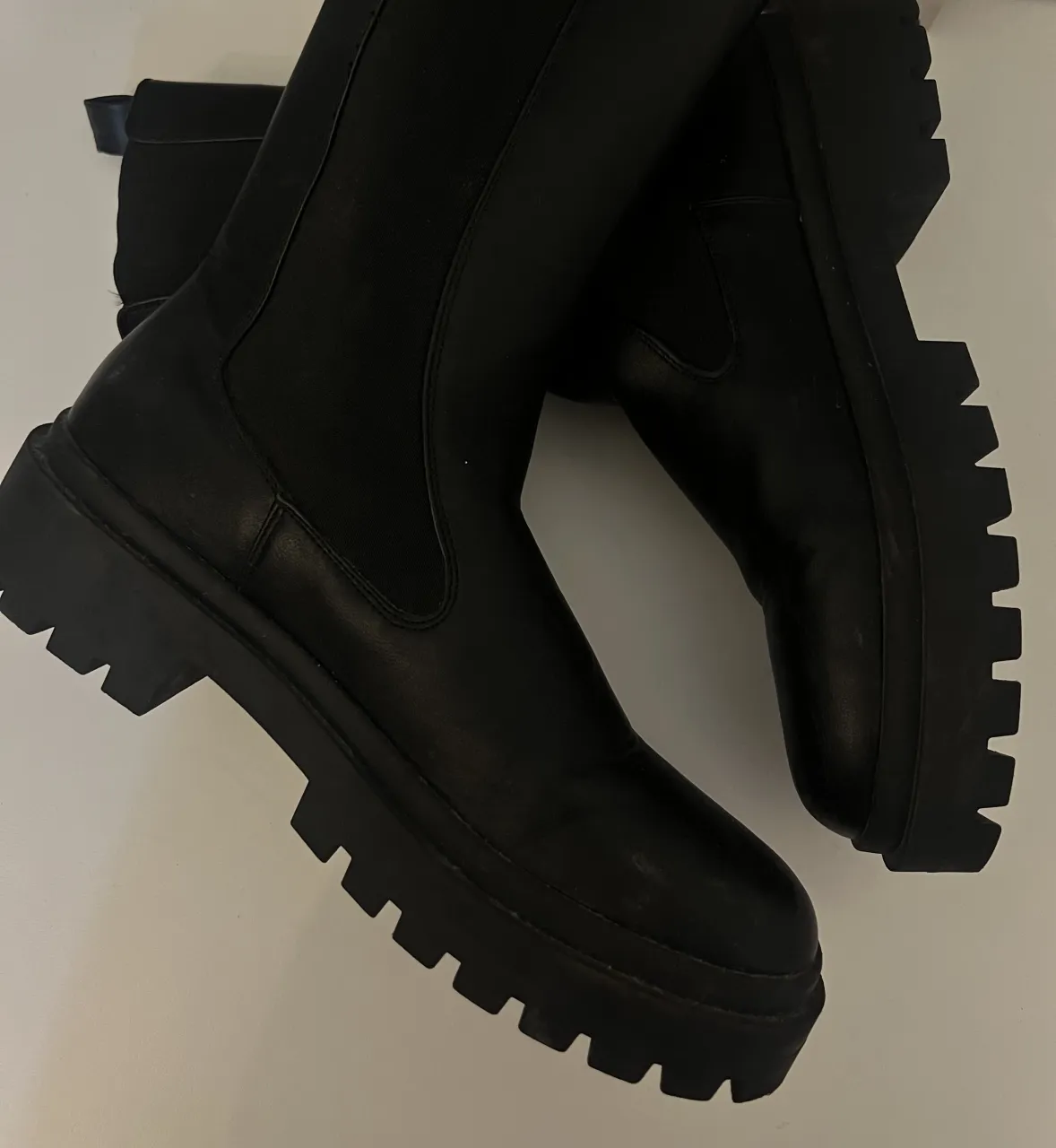 Botas negras de cuero con plataforma gruesa y caña alta.