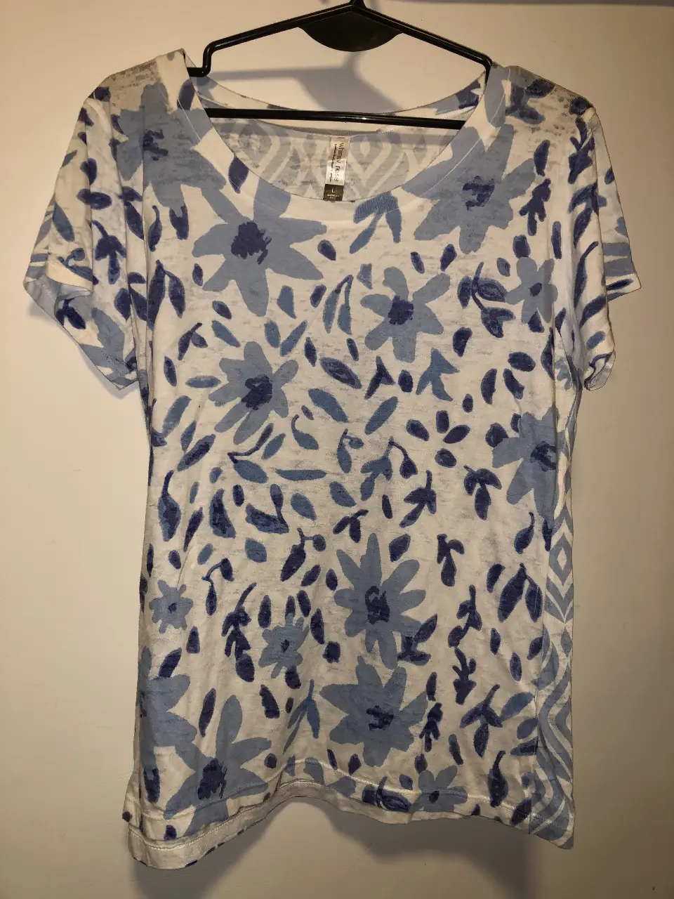 Remera de mujer con estampado floral en tonos azules sobre fondo blanco. Ideal para un look casual y fresco.