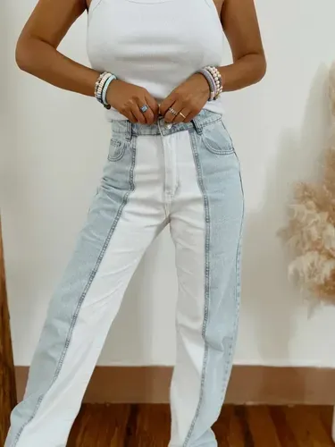 Jeans de tiro alto con diseño de bloques de color blanco y celeste. Poseen roturas en los bajos. El corte recto con formato barrel.