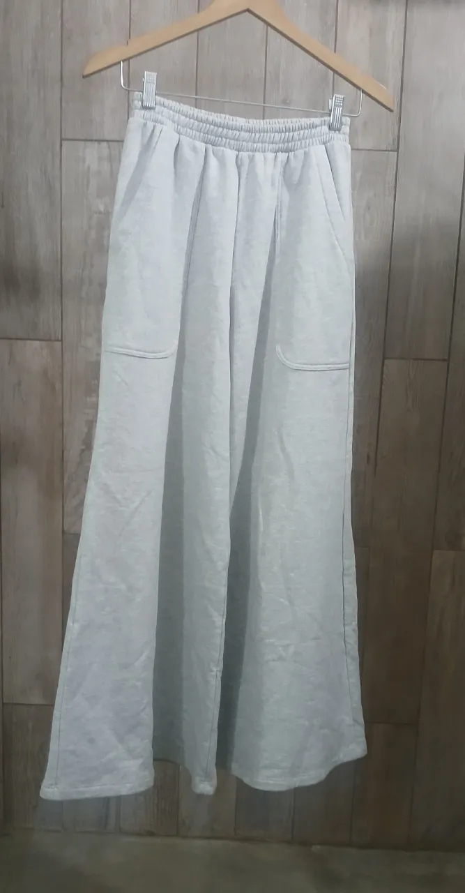 Pantalón de friza gris melange claro con cintura elastizada y bolsillos laterales.