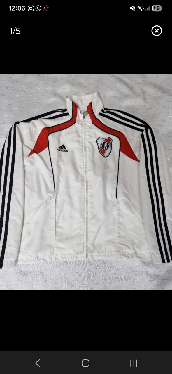 Conjunto deportivo de River Plate, ideal para los fanáticos del club. Incluye campera y pantalón, ambos con el escudo del equipo y las icónicas tres tiras de Adidas. Perfecto para entrenar o para un look casual.