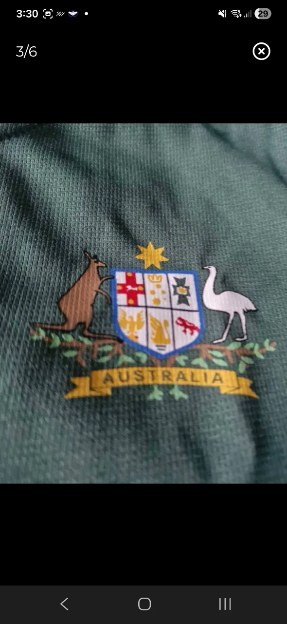 Remera manga corta de color verde con escudo de Australia bordado en el frente.