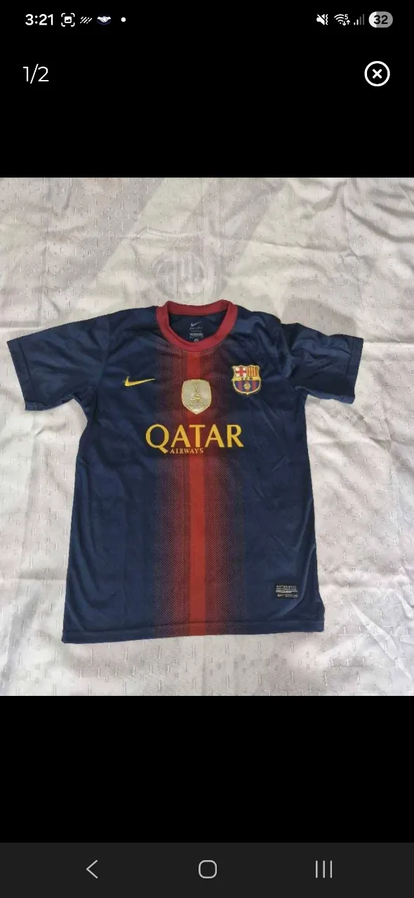 Remera de fútbol azul y roja con el número 10 y el nombre MESSI en la espalda. Logo de Qatar Airways y escudo del equipo en el frente.