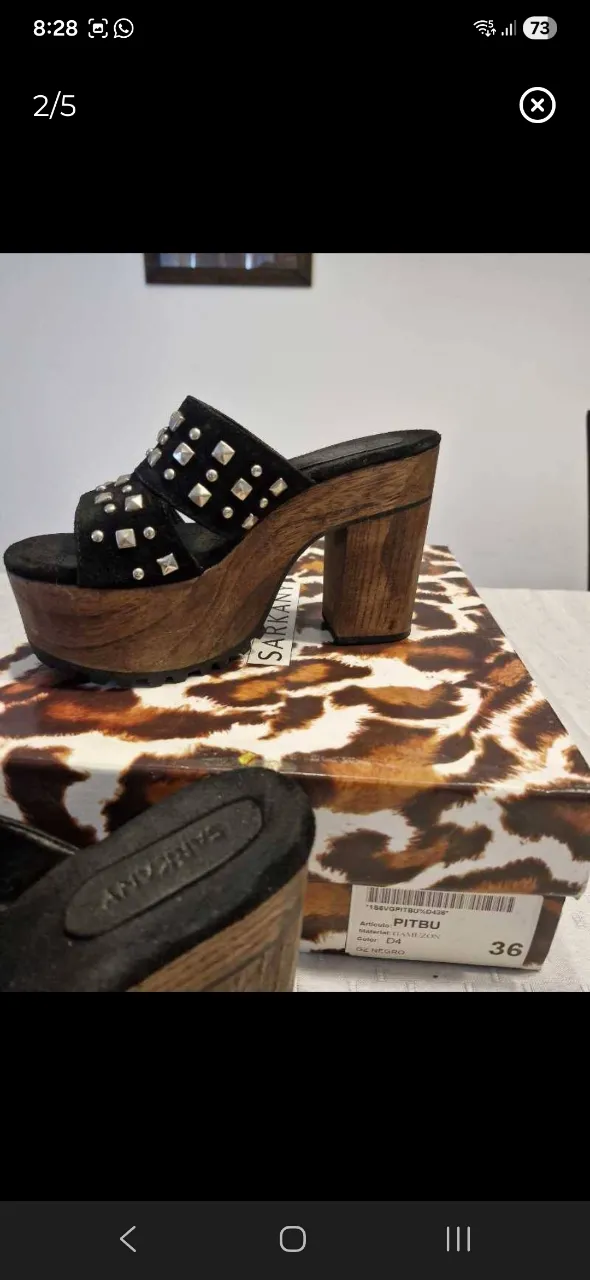 Sandalias negras con plataforma de madera y tachas plateadas. Diseño de tiras anchas.