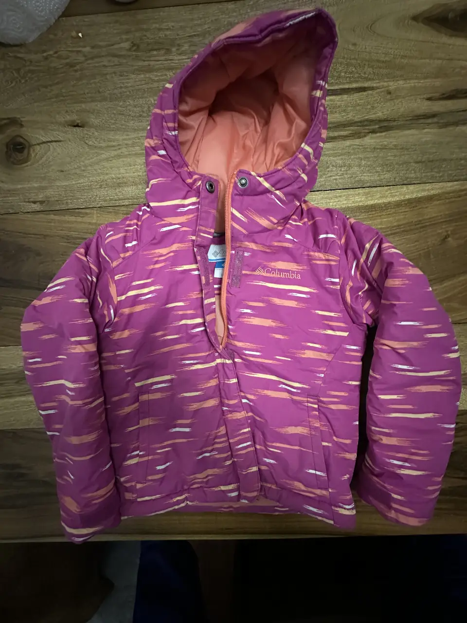 Campera de abrigo para niña Columbia, color rosa con detalles en amarillo y blanco. Con capucha y cierre frontal. Talle XXS.