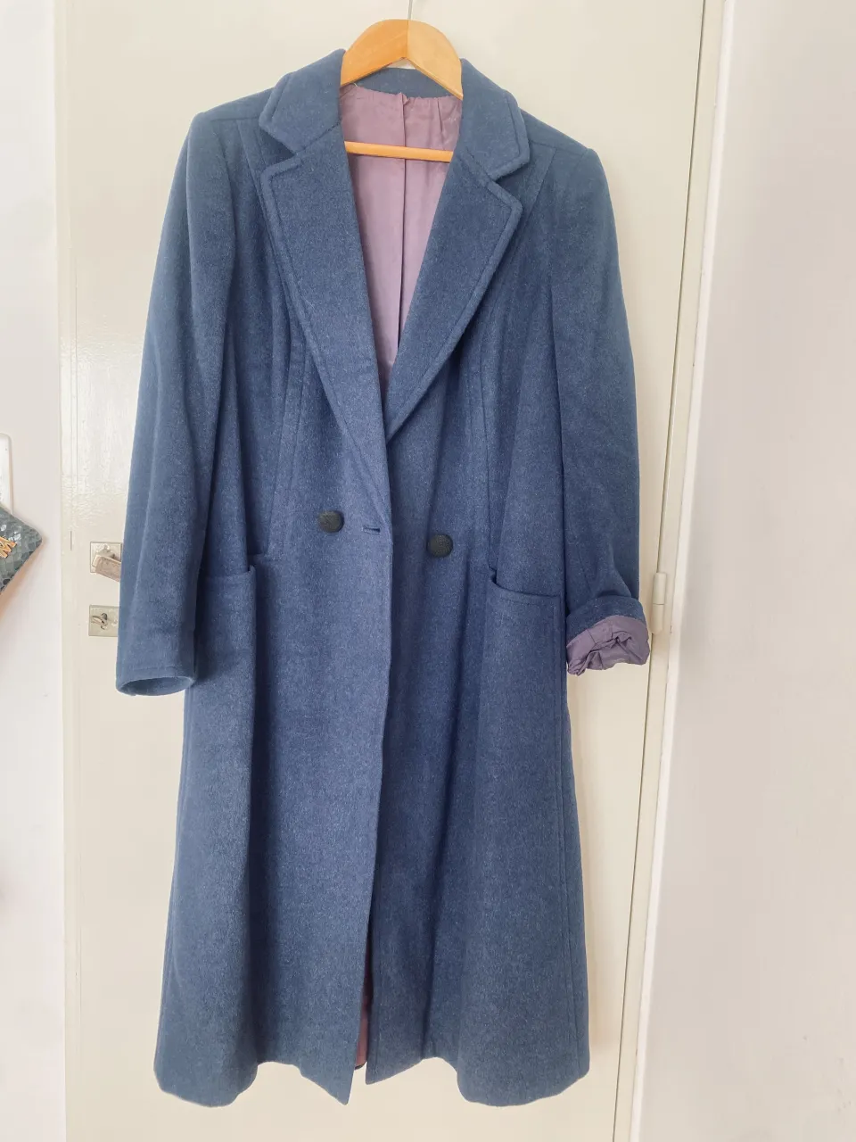 sobretodo largo de paño y lana azul, con corte clásico y solapas. ideal para un look elegante y abrigado en invierno. posee un cinturón en la parte trasera para ajustar la silueta. 

hombros 42, axilas 53, mangas 63, largo 117
