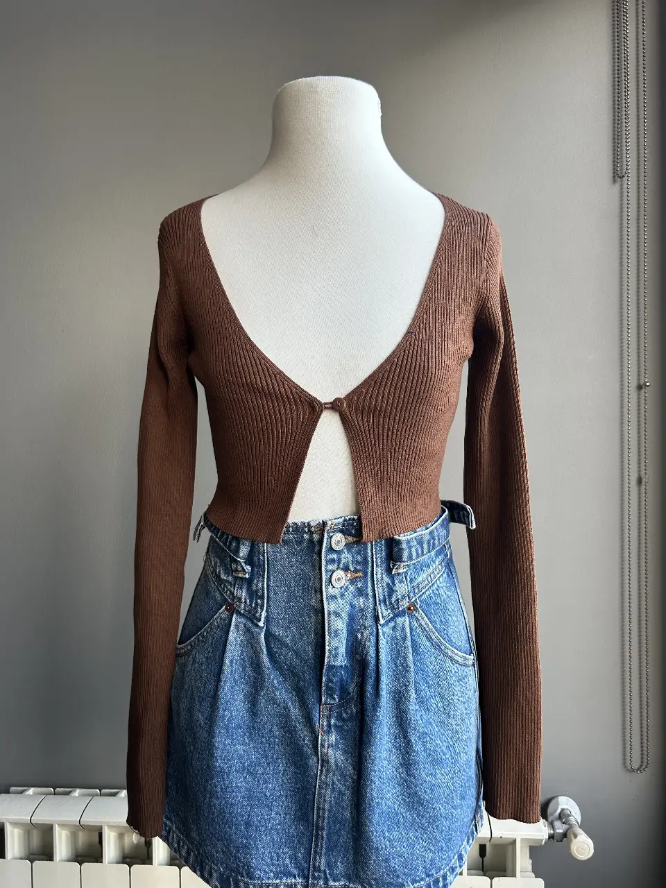 Top tejido de manga larga en color marrón, con un diseño que se abrocha en el centro. Ideal para un look casual y moderno. talle s