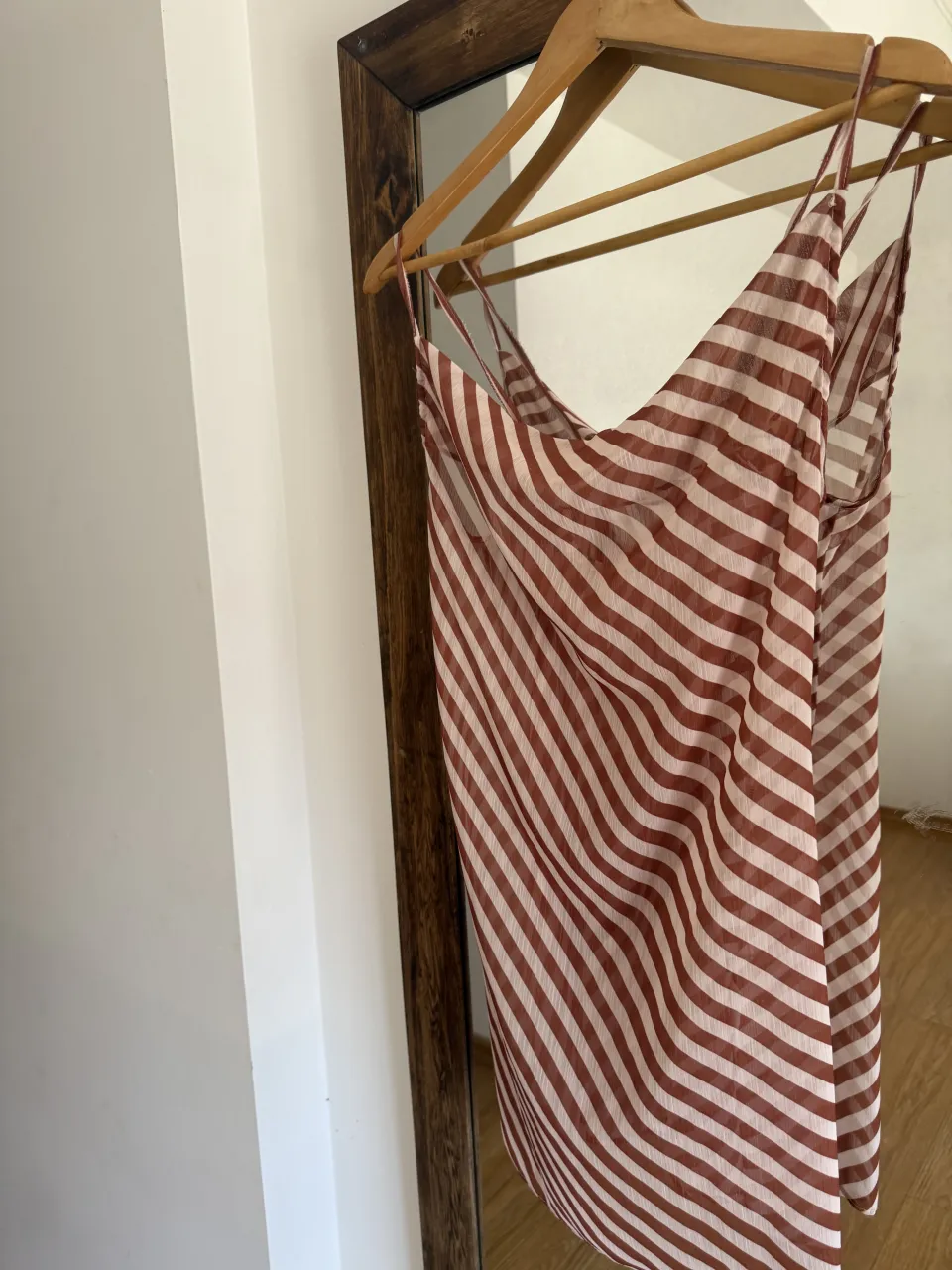 Vestido corto a rayas blancas y marrones, con tiras finas y lazo en la espalda.