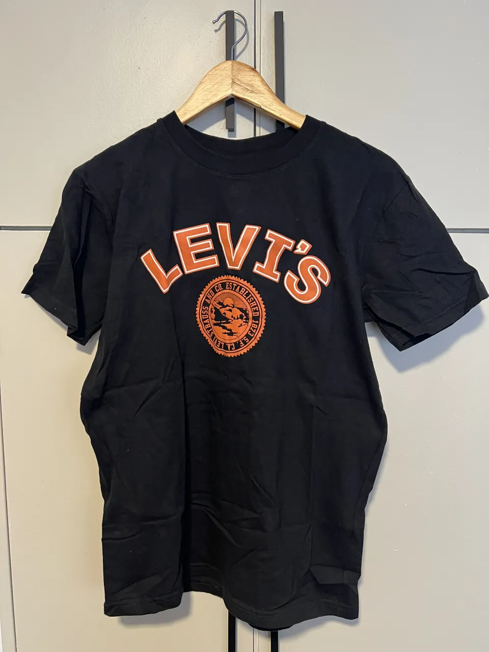 Remera negra de manga corta con estampa "Levi's" en naranja y blanco. Ideal para un look casual y urbano.
largo a hombro: 65
ancho axila a axila: 48
mangas: 20