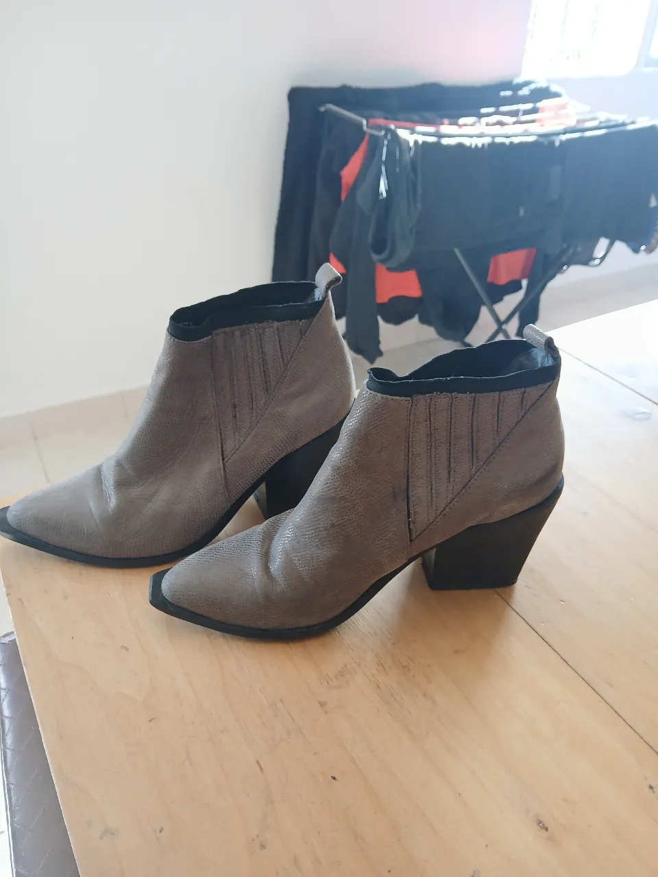 Botas de cuero grises con taco y punta cuadrada.